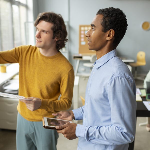 Plano aproximado de uma pessoa a apontar com uma caneta para gráficos de barras e métricas de desempenho