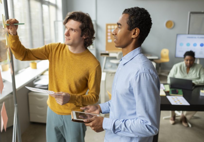 Plano aproximado de uma pessoa a apontar com uma caneta para gráficos de barras e métricas de desempenho