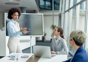 Black female entrepreneur talking while holding business presentation in the office.