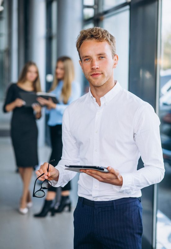 Three collegues working at a car showroom